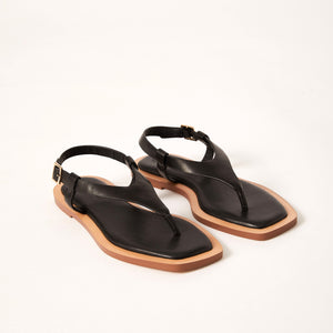 Double 3/4 view of Juniper Sandal in Black, showcasing its premium Sheep leather construction, sleek cushioned footbed, and elegantly designed wrap-around leather straps for a modern twist on a classic sandal