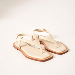 Double 3/4 view of Juniper Sandal in Crema, showcasing its premium Sheep leather construction, sleek cushioned footbed, and elegantly designed wrap-around leather straps for a modern twist on a classic sandal