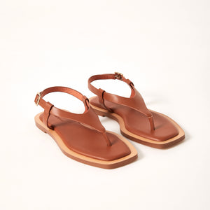 Double 3/4 view of Juniper Sandal in Tan, showcasing its premium Sheep leather construction, sleek cushioned footbed, and elegantly designed wrap-around leather straps for a modern twist on a classic sandal.
