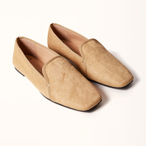A pair of champagne-colored ballet flats with a square toe design, made of pony hair material, displayed in a 3/4 view in a double presentation