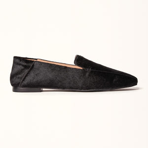  A black ballet flat with a square toe design crafted from pony hair material, displayed in a side view.